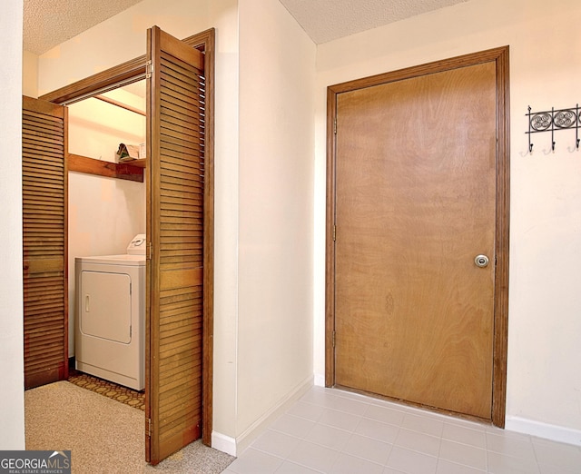 laundry room featuring washer / dryer, laundry area, a textured ceiling, and baseboards