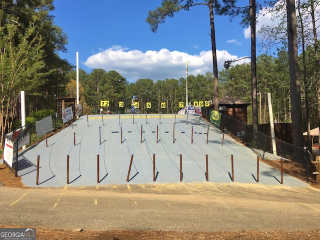 view of community with fence and a wooded view