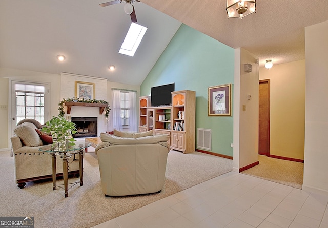 living area with carpet floors, a skylight, a fireplace, and visible vents