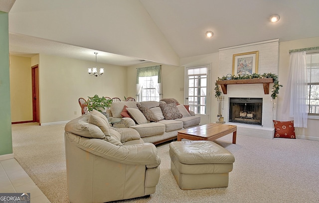 carpeted living room featuring a chandelier, high vaulted ceiling, a brick fireplace, and baseboards