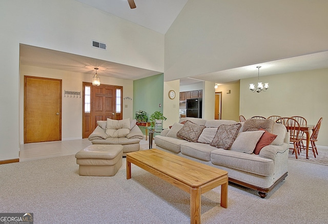 living area with a notable chandelier, light colored carpet, a high ceiling, visible vents, and baseboards