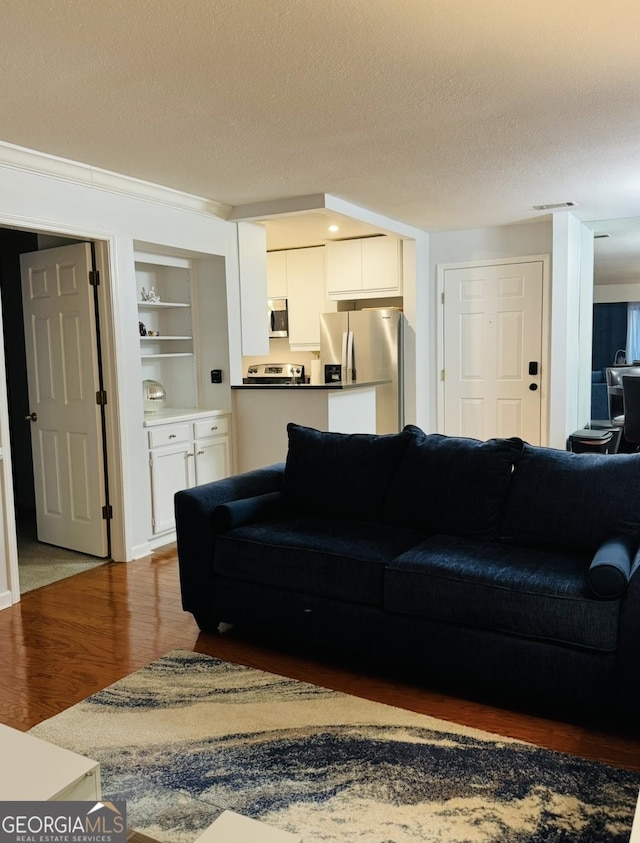 living room with a textured ceiling and wood finished floors