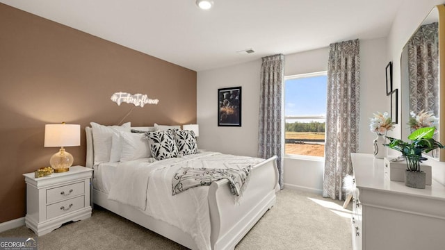 bedroom featuring light colored carpet and baseboards