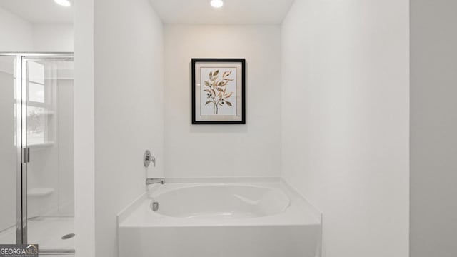 bathroom with a shower stall, a bath, and recessed lighting