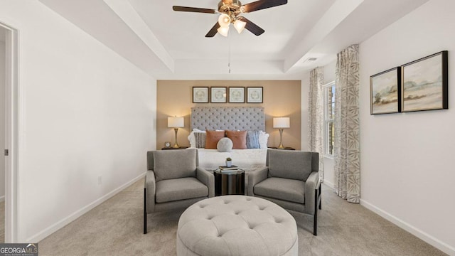 bedroom with a ceiling fan, a raised ceiling, light carpet, and baseboards