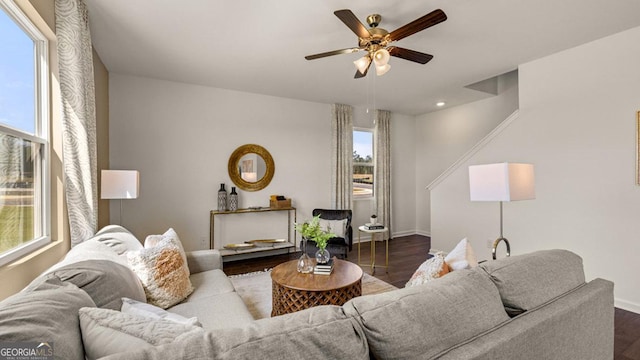 living area with a ceiling fan, dark wood-style flooring, and baseboards