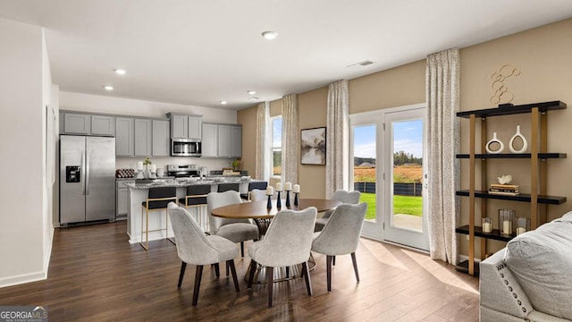 dining room featuring baseboards, dark wood finished floors, and recessed lighting