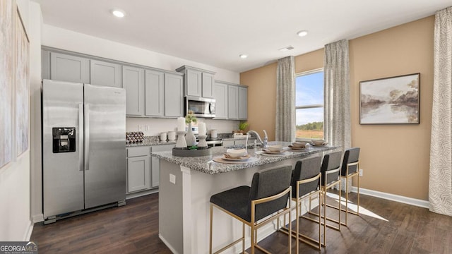 kitchen with dark wood-style floors, appliances with stainless steel finishes, and gray cabinets