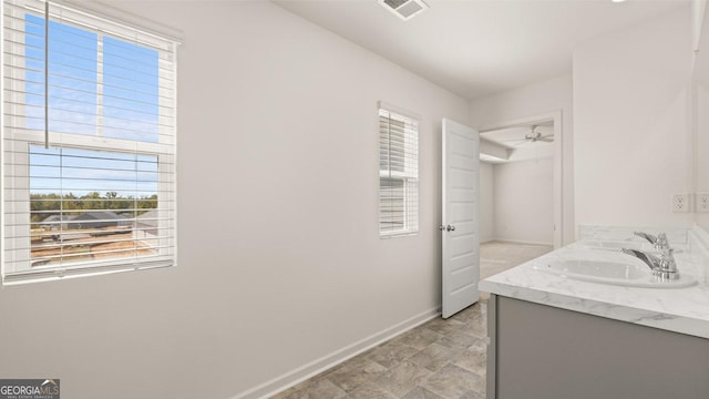 bathroom featuring double vanity, a sink, visible vents, and baseboards