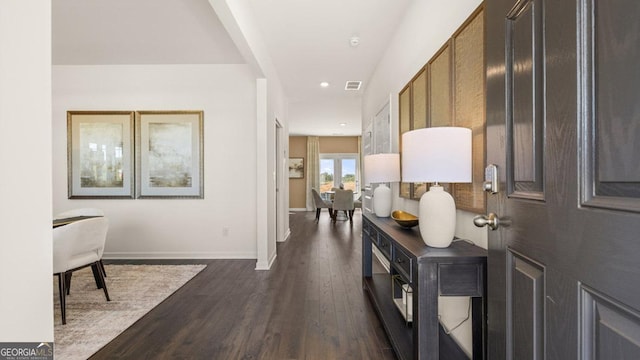 corridor with dark wood-type flooring, recessed lighting, and baseboards