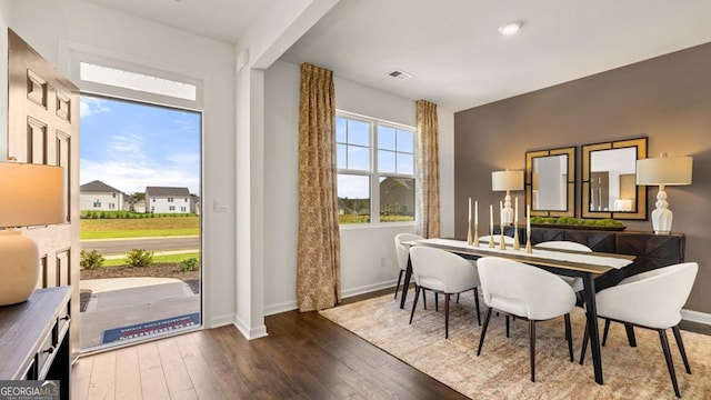 dining room with wood-type flooring, visible vents, and baseboards