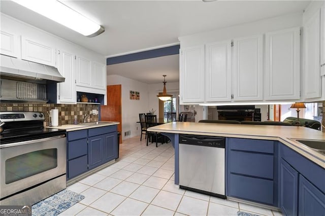 kitchen featuring white cabinetry, light countertops, appliances with stainless steel finishes, blue cabinetry, and decorative backsplash