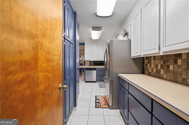 kitchen featuring light tile patterned floors, tasteful backsplash, white cabinets, dishwasher, and light countertops