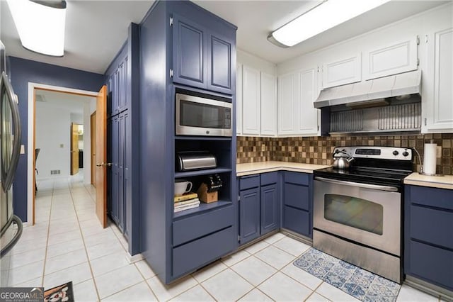 kitchen featuring appliances with stainless steel finishes, blue cabinets, under cabinet range hood, and light tile patterned floors