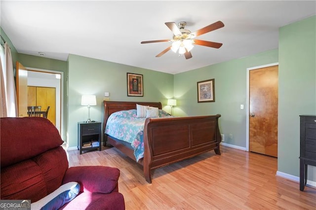 bedroom with light wood finished floors, ceiling fan, and baseboards