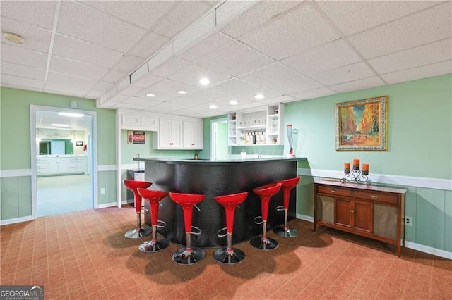 bar featuring recessed lighting, a drop ceiling, and a bar