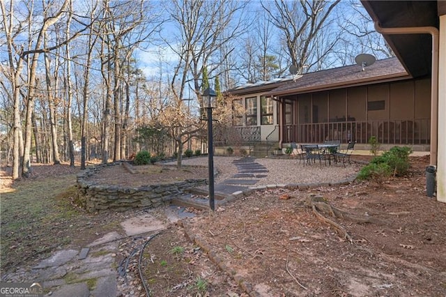 view of yard with a sunroom and a patio