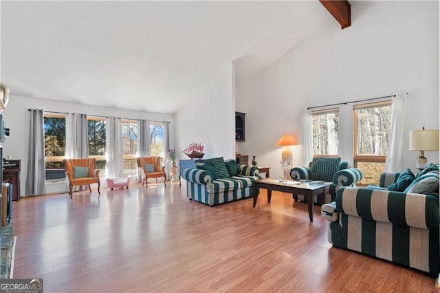 living area with light wood-style floors, high vaulted ceiling, and beam ceiling