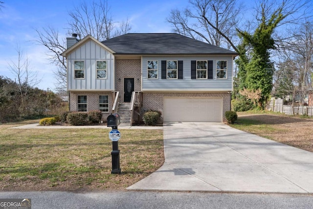 split foyer home featuring brick siding, concrete driveway, a chimney, board and batten siding, and a front yard