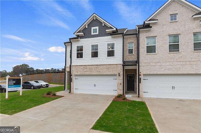 view of property featuring a garage, a front yard, concrete driveway, and brick siding