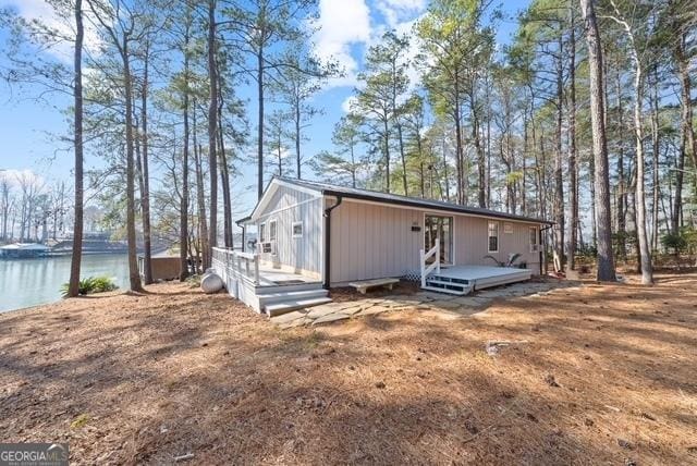 view of side of property featuring a deck with water view