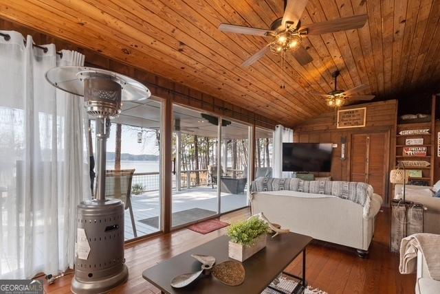 living room with wooden ceiling, a ceiling fan, wood finished floors, and lofted ceiling