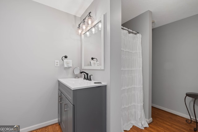 full bath with vanity, baseboards, and wood finished floors