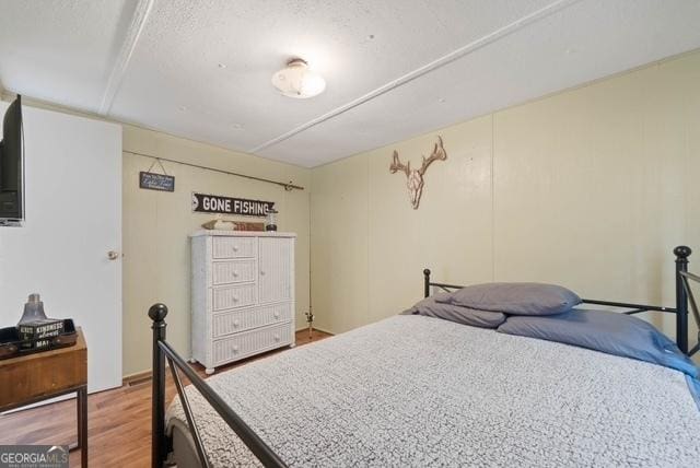 bedroom with a textured ceiling and light wood-style floors