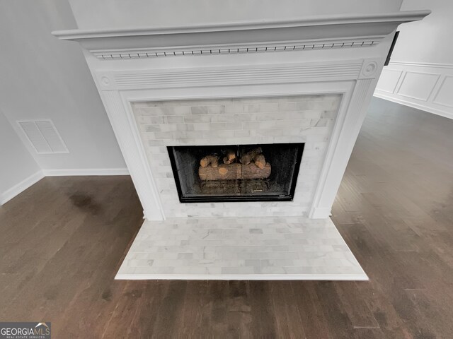 1235 Park Pass Way, Suwanee, GA 30024 - details with visible vents, a decorative wall, a fireplace with flush hearth, wainscoting, and wood finished floors