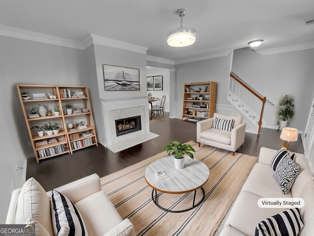 living room featuring wood finished floors, crown molding, stairway, and a premium fireplace