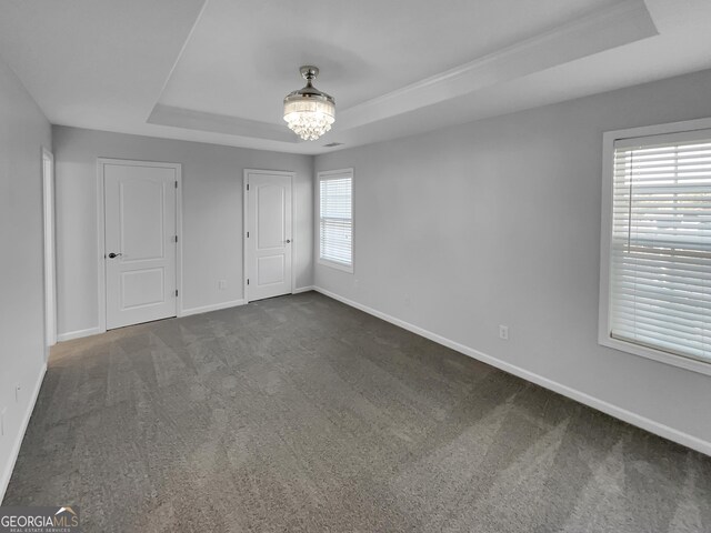 1235 Park Pass Way, Suwanee, GA 30024 - unfurnished bedroom featuring dark colored carpet, a raised ceiling, a notable chandelier, and baseboards