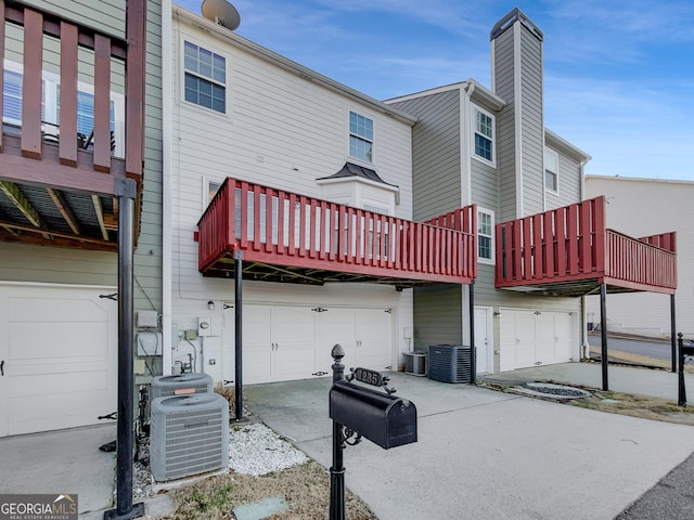 1235 Park Pass Way, Suwanee, GA 30024 - rear view of property with a garage, a chimney, and central air condition unit