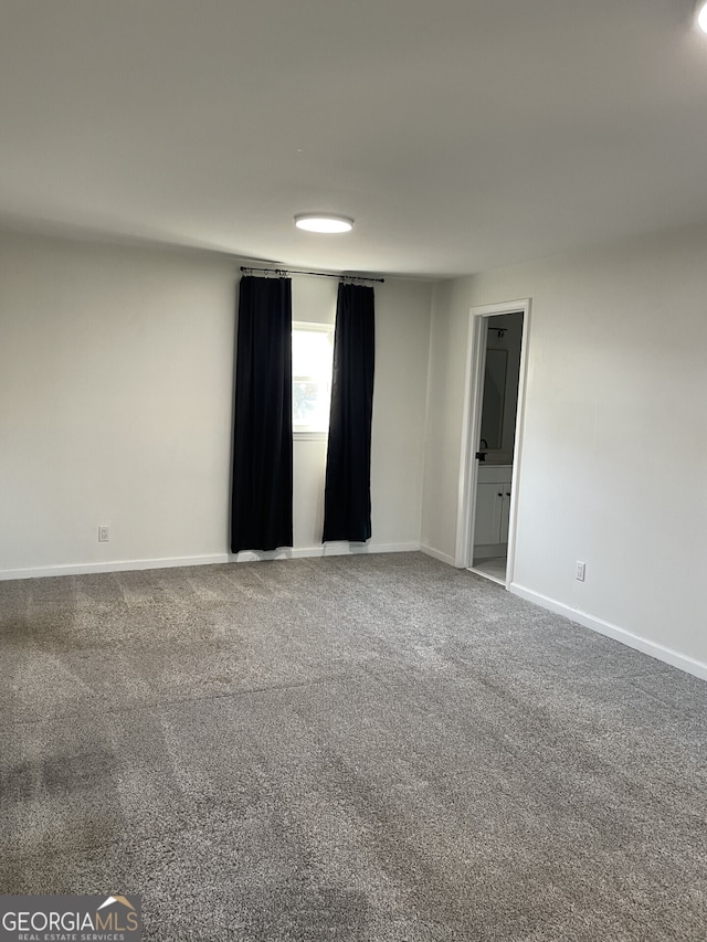 unfurnished room featuring carpet flooring and baseboards