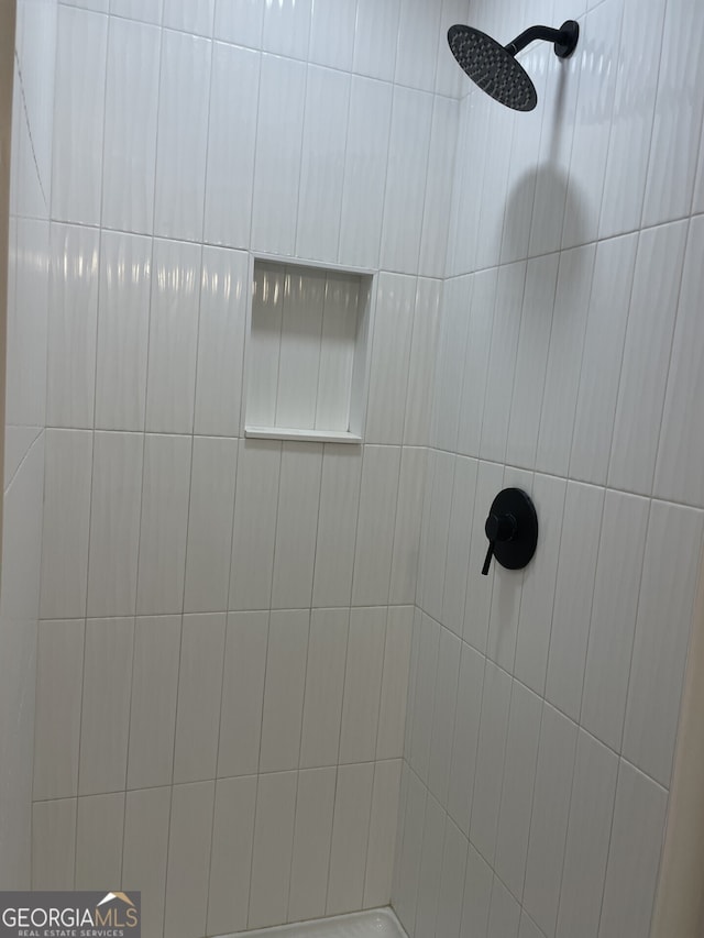 interior details featuring tiled shower