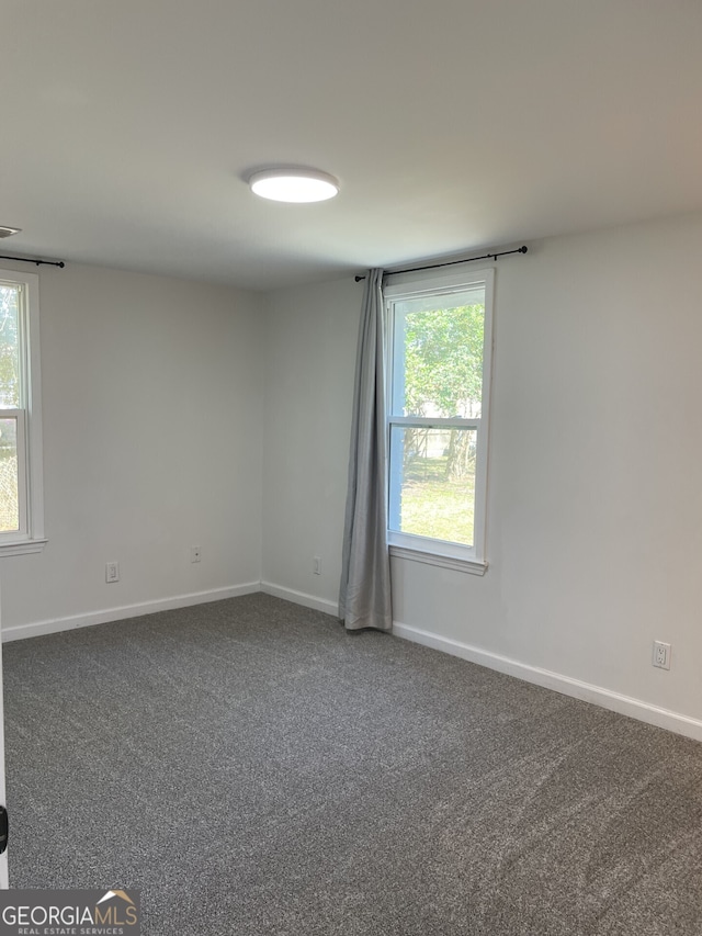 empty room with carpet and baseboards