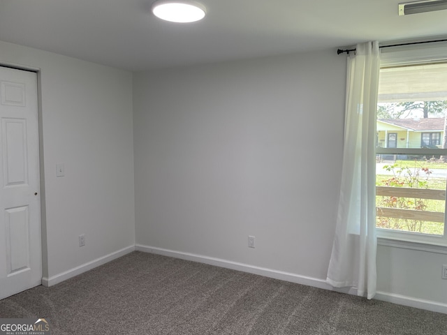 unfurnished room featuring baseboards, visible vents, and carpet flooring