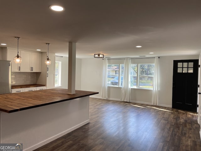 kitchen featuring dark wood-style floors, butcher block countertops, white cabinetry, and decorative backsplash