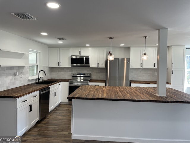 kitchen featuring visible vents, butcher block counters, a sink, and appliances with stainless steel finishes