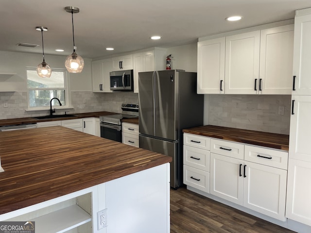 kitchen featuring open shelves, visible vents, wooden counters, appliances with stainless steel finishes, and a sink