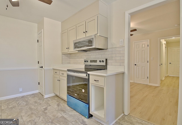 kitchen with tasteful backsplash, a ceiling fan, light countertops, and electric stove