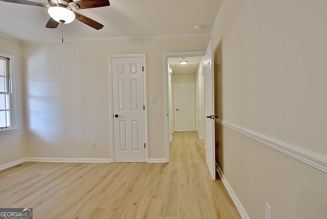 interior space with light wood finished floors, baseboards, ornamental molding, and ceiling fan