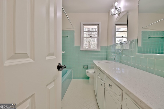 full bathroom featuring shower / tub combination, tile patterned flooring, toilet, vanity, and tile walls