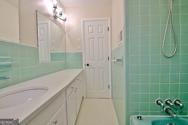 bathroom featuring a wainscoted wall, shower / bathtub combination, tile walls, and vanity