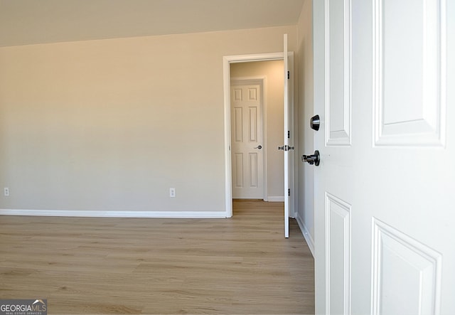 empty room with light wood-type flooring and baseboards