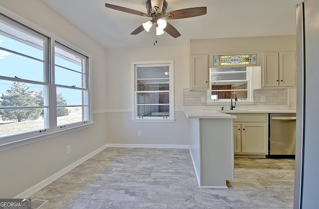 kitchen featuring light countertops, visible vents, decorative backsplash, dishwasher, and baseboards