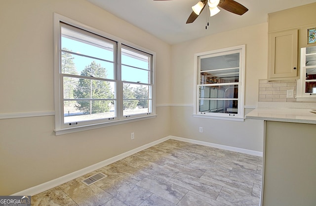 unfurnished dining area with visible vents, ceiling fan, and baseboards