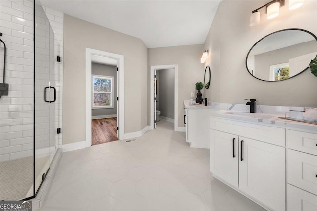 bathroom with visible vents, toilet, a stall shower, vanity, and baseboards