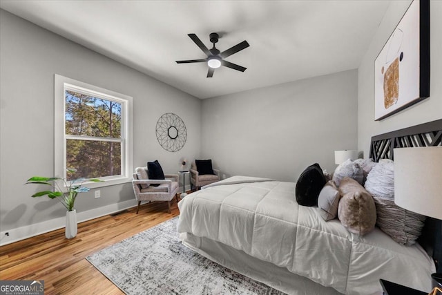 bedroom with wood finished floors, a ceiling fan, and baseboards