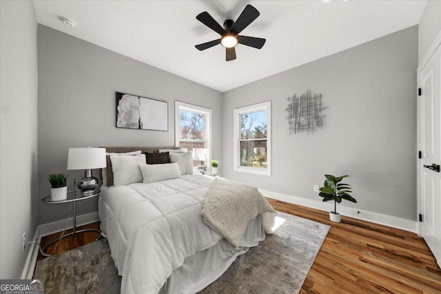 bedroom featuring ceiling fan, wood finished floors, and baseboards