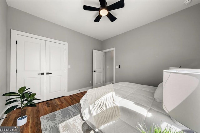 bedroom featuring a closet, wood finished floors, a ceiling fan, and baseboards